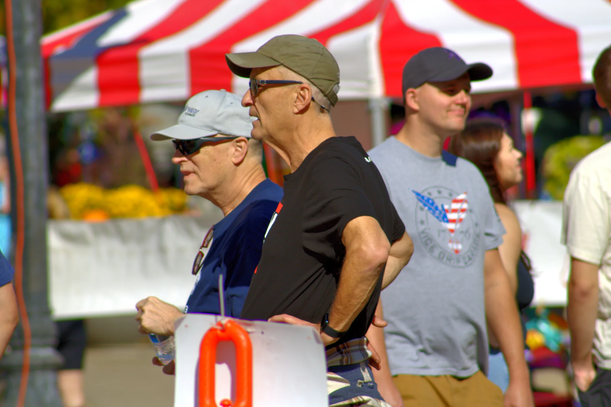 Visitors walking past a red-and-white striped fair tent at Baraboo's 2026 Fall Fair on the Square