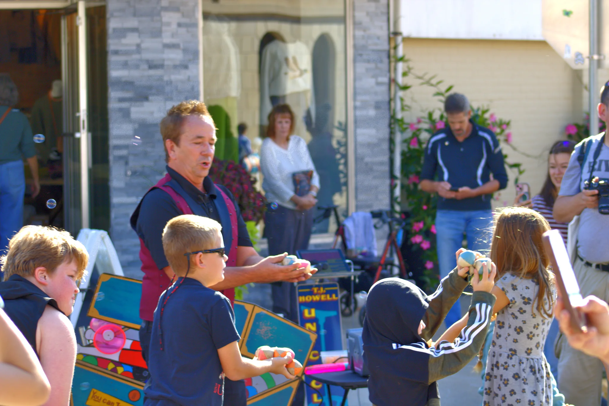 Adults and children talking around a colorful activity table at Baraboo's 2026 Fall Fair on the Square