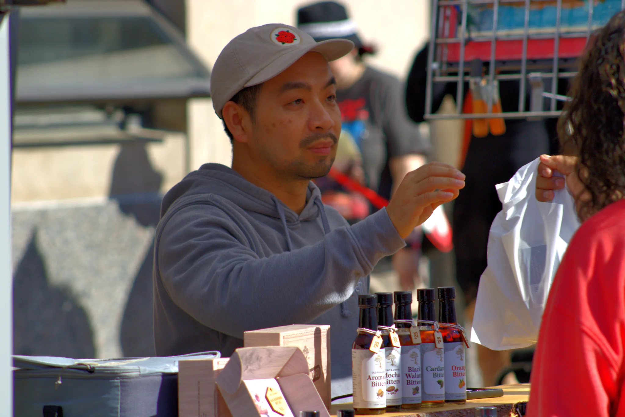 Vendor handing an item across a craft booth table at Baraboo's 2026 Fall Fair on the Square