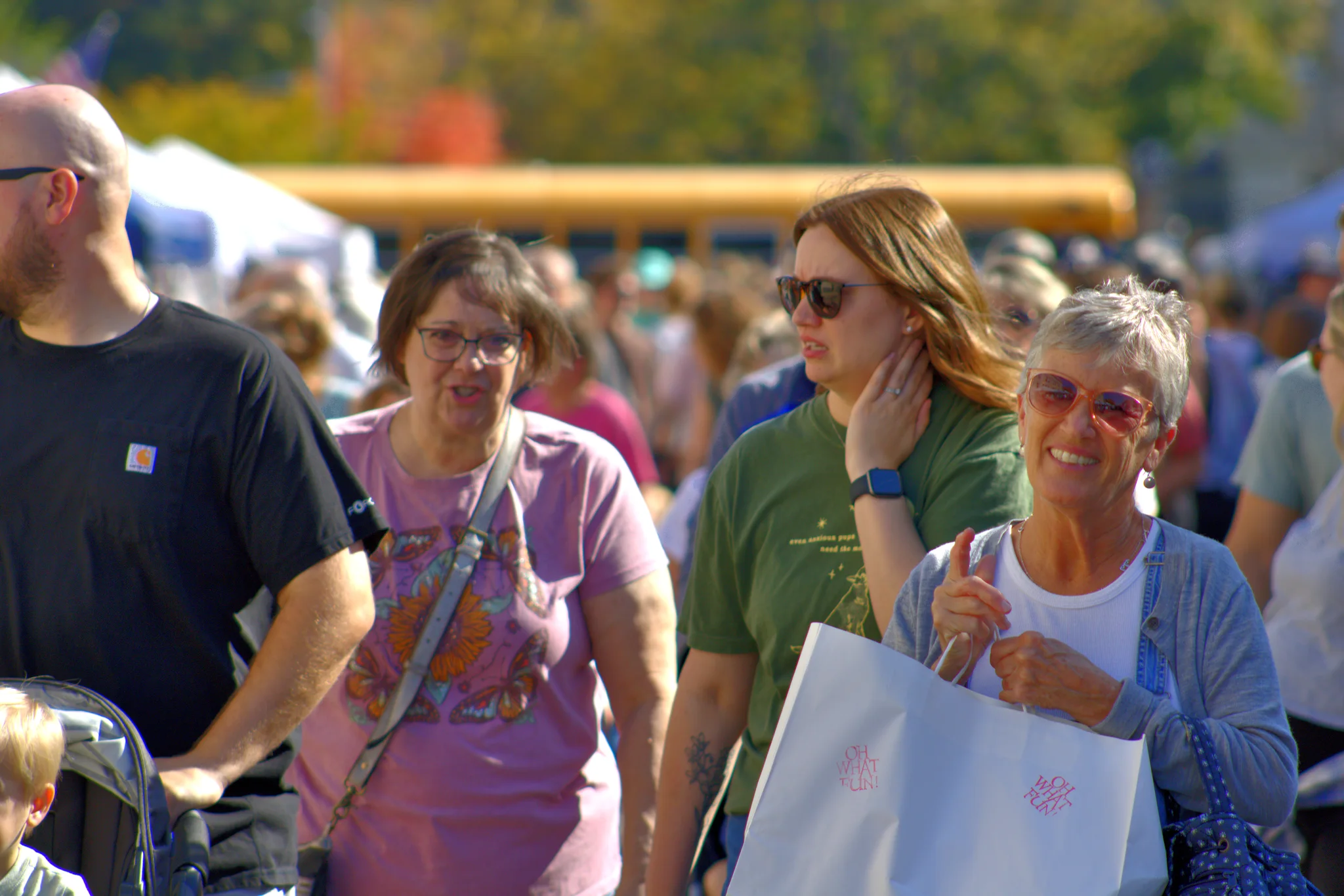 Three shoppers smiling while walking through the fair at Baraboo's 2026 Fall Fair on the Square