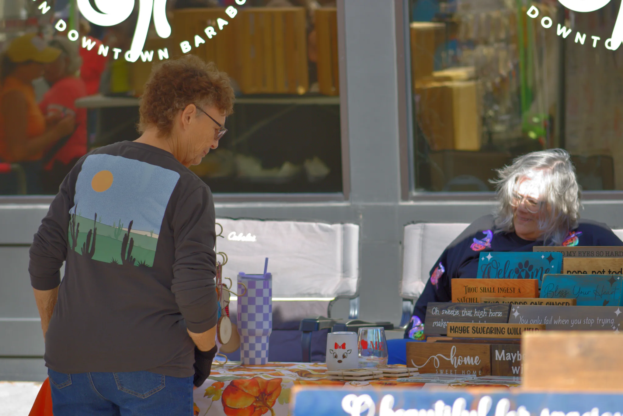 Shopper talking with a vendor at a downtown booth at Baraboo's 2026 Fall Fair on the Square