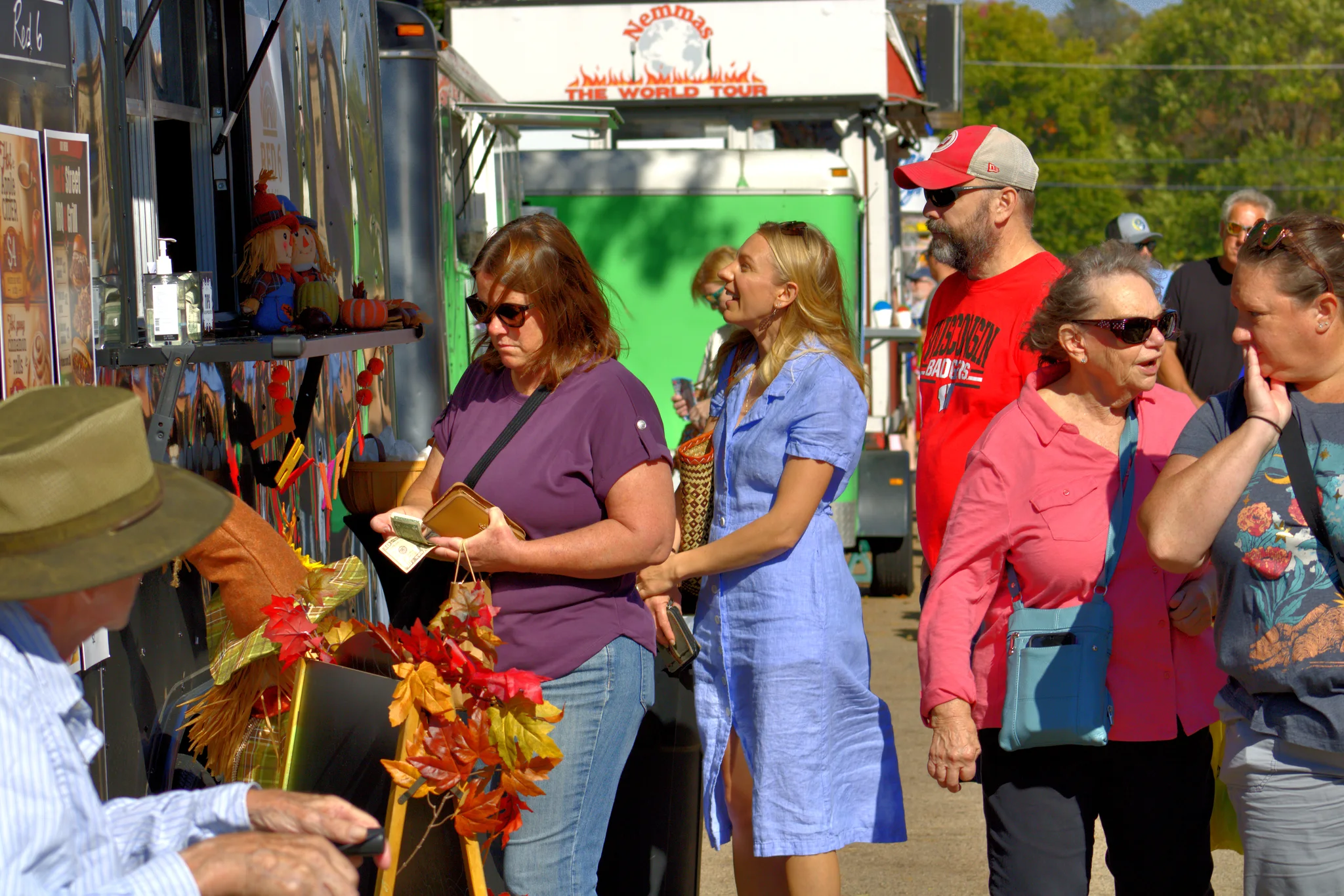 Shoppers moving between flower displays and food stalls at Baraboo's 2026 Fall Fair on the Square