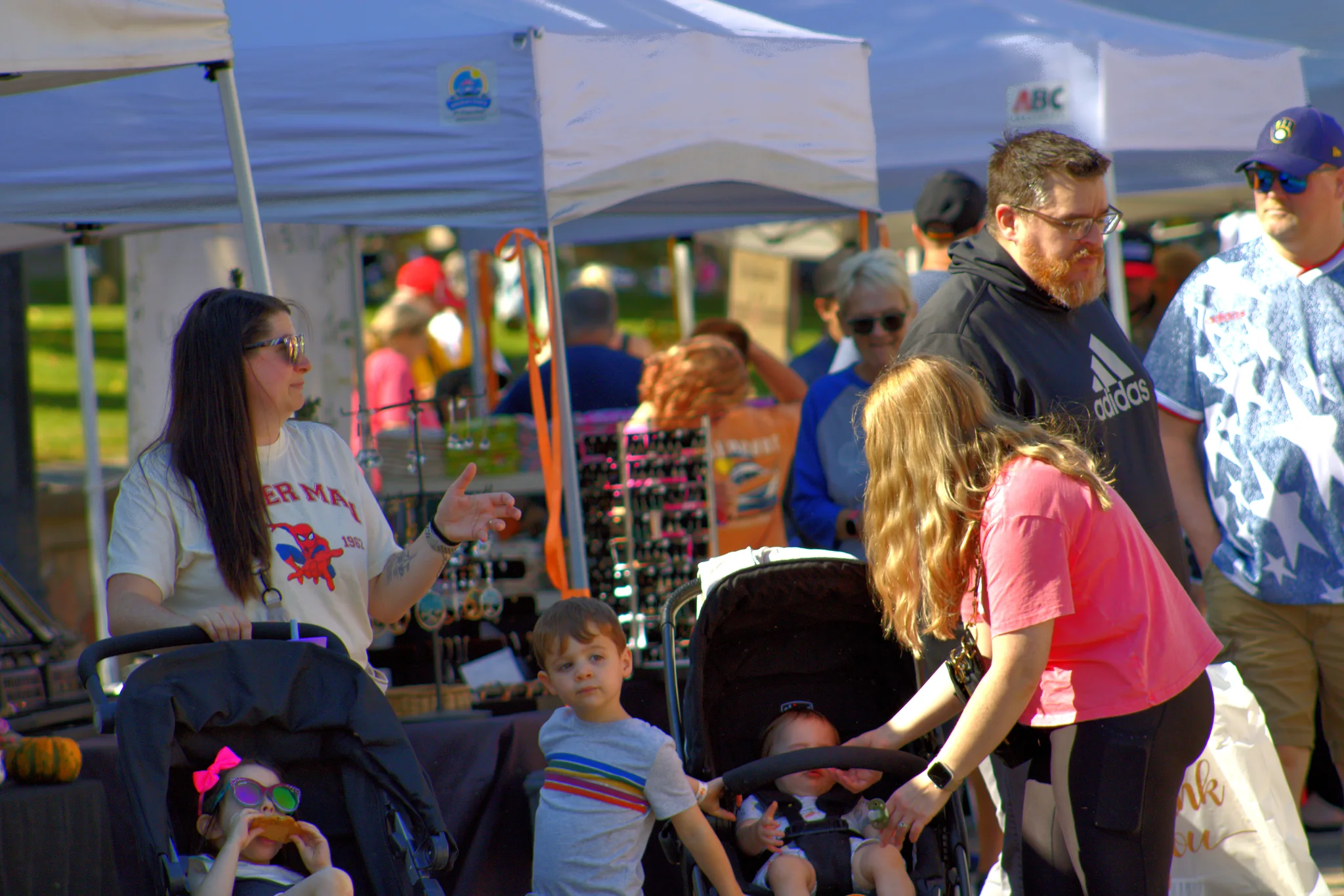 Families visiting a craft booth beneath white tents at Baraboo's 2026 Fall Fair on the Square