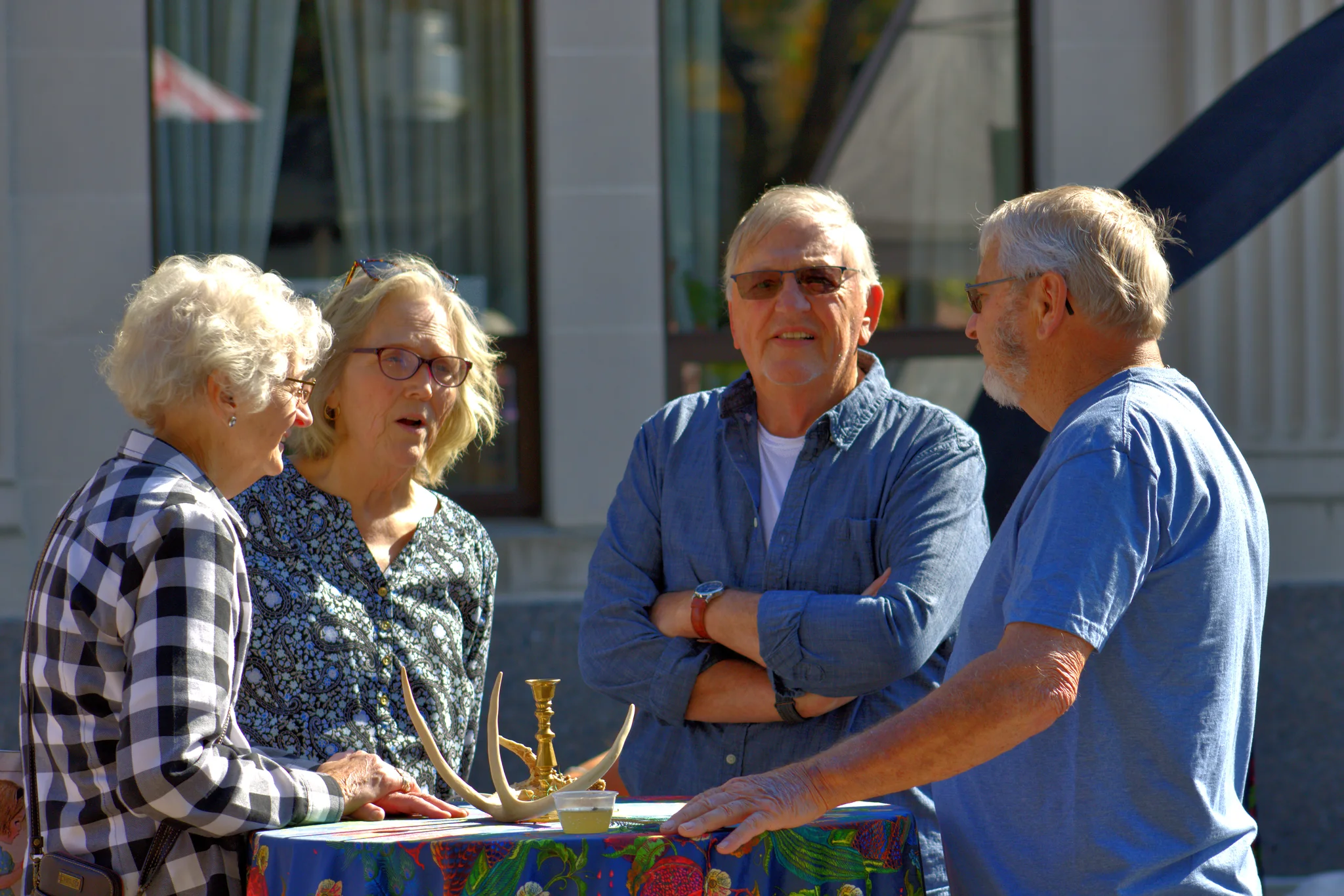 Four visitors chatting around a vendor table at Baraboo's 2026 Fall Fair on the Square
