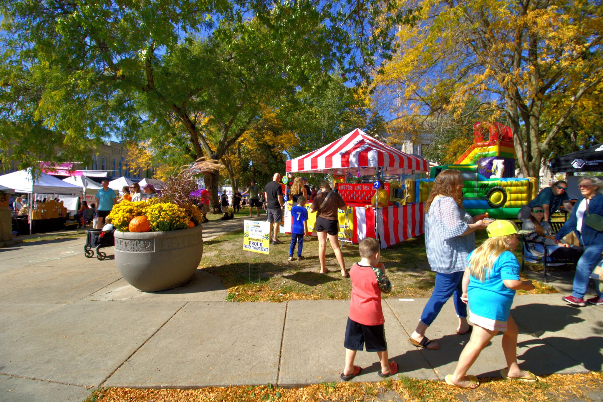 Families and colorful fair tents on the courthouse lawn at Fall Fair on the Square