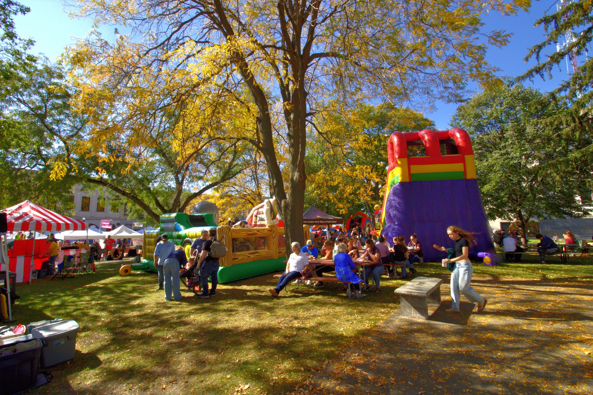 Families gathered near a striped tent and inflatable attraction at Baraboo's 2026 Fall Fair on the Square