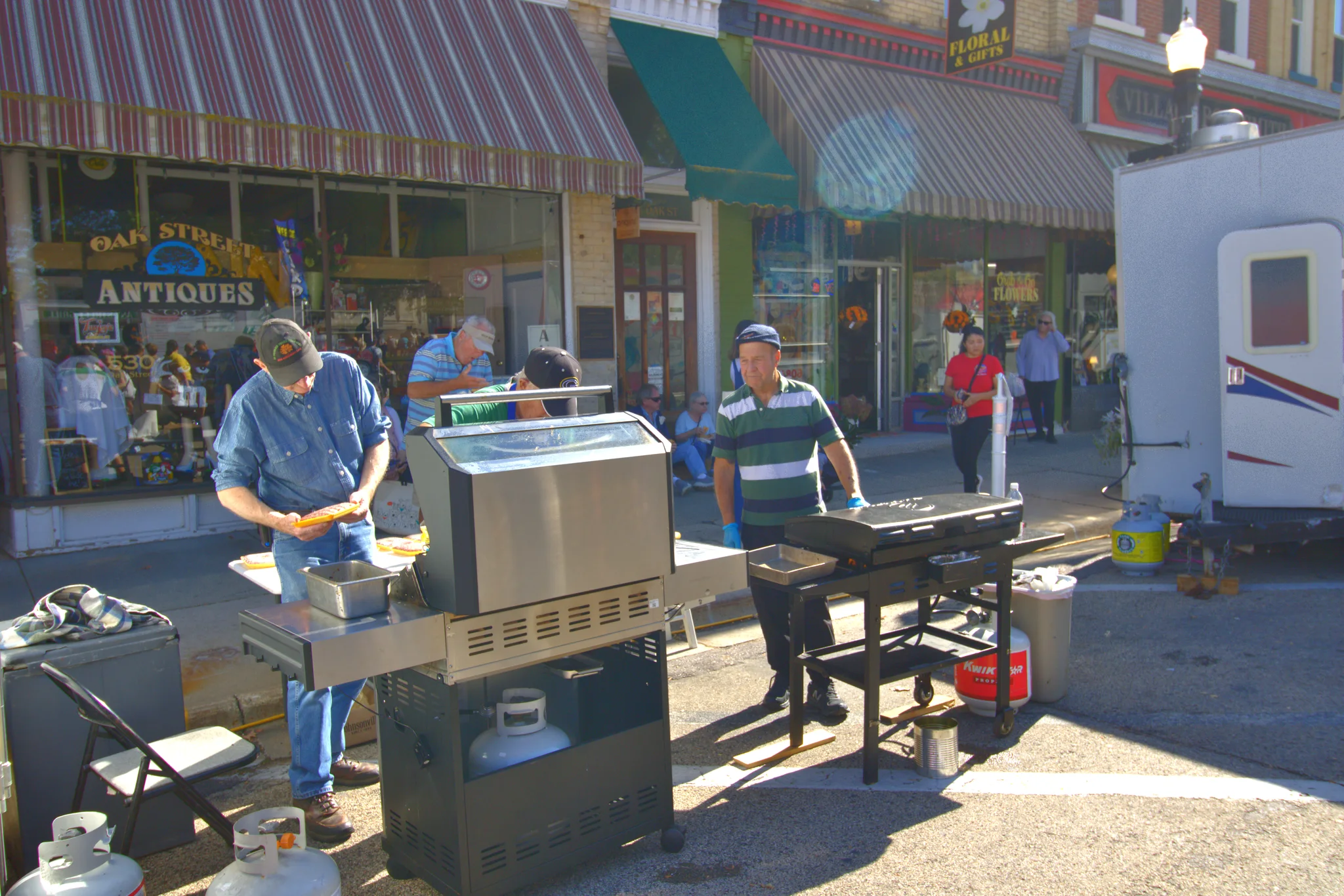 Food vendor preparing a meal beside downtown storefronts at Baraboo's 2026 Fall Fair on the Square