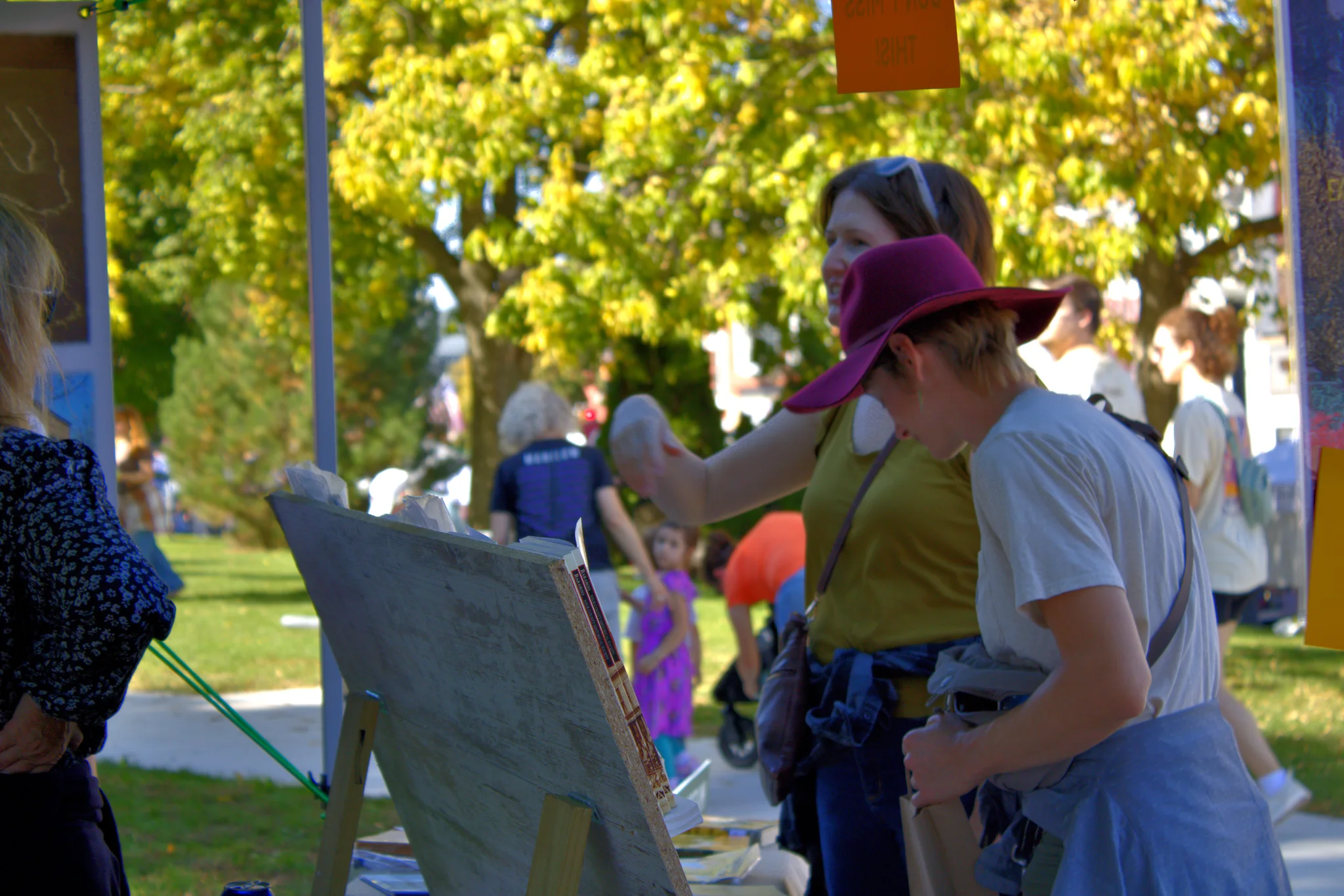 Visitor examining artwork at an outdoor display at Baraboo's 2026 Fall Fair on the Square