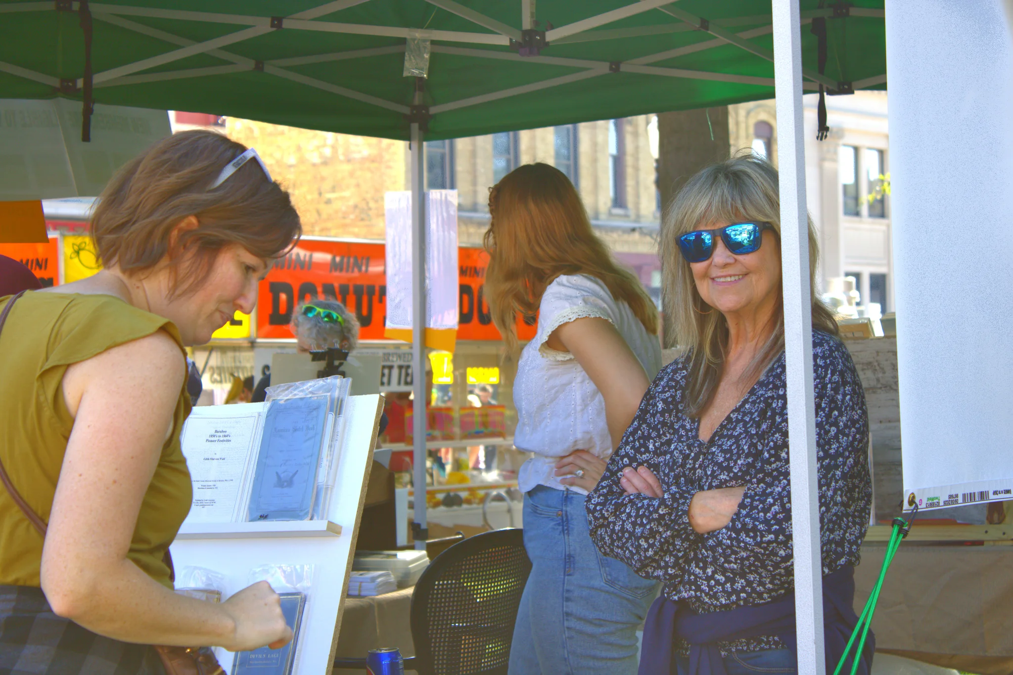 Shoppers smiling as they browse a fair booth at Baraboo's 2026 Fall Fair on the Square