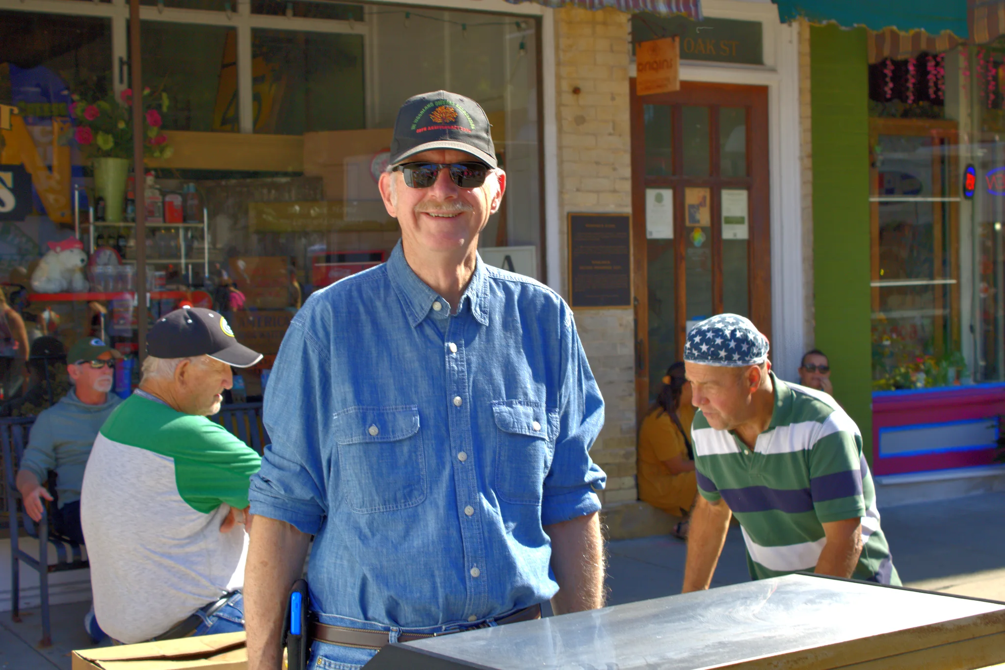Smiling vendor standing in front of a downtown storefront at Baraboo's 2026 Fall Fair on the Square