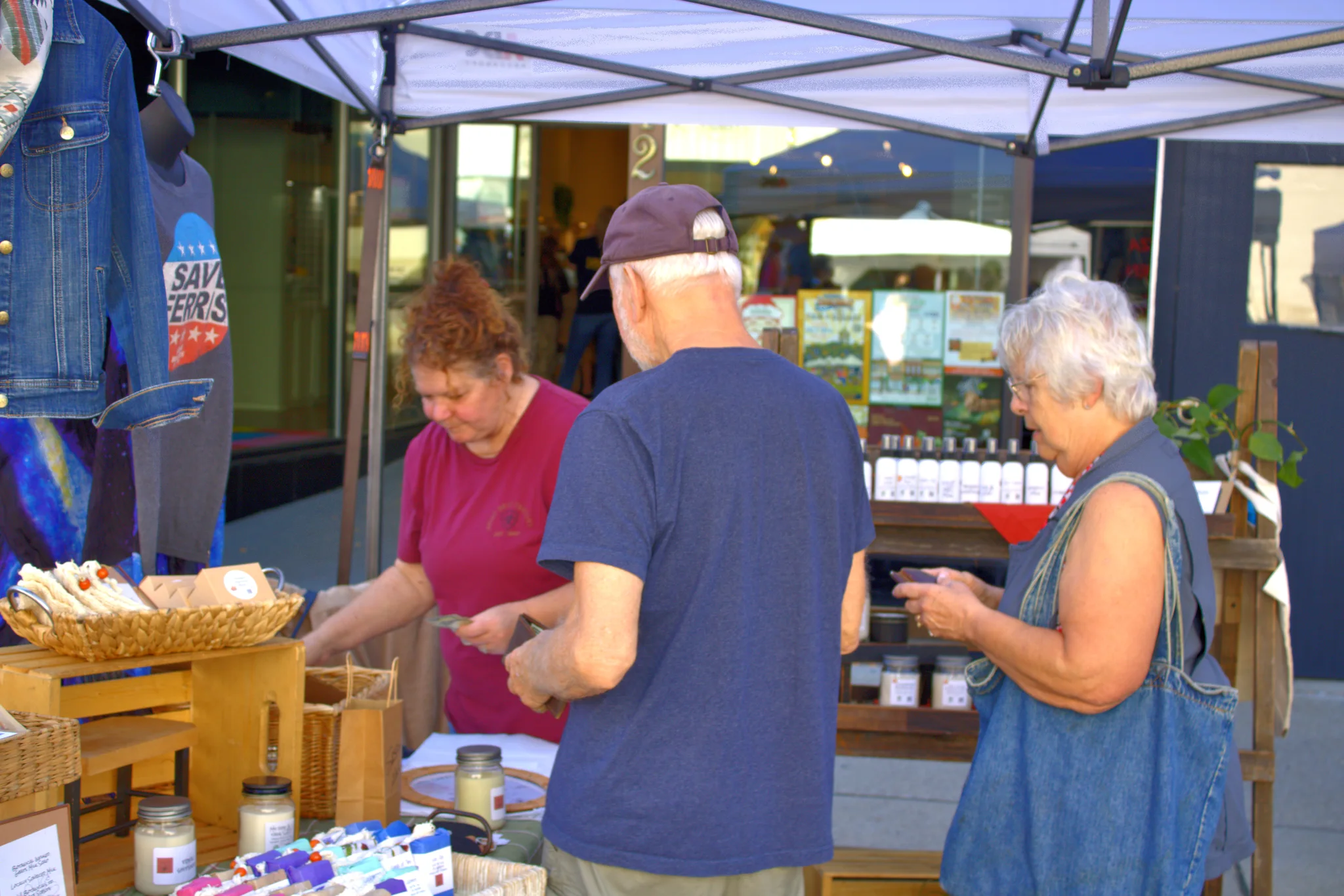 Customers choosing items from a wooden booth display at Baraboo's 2026 Fall Fair on the Square