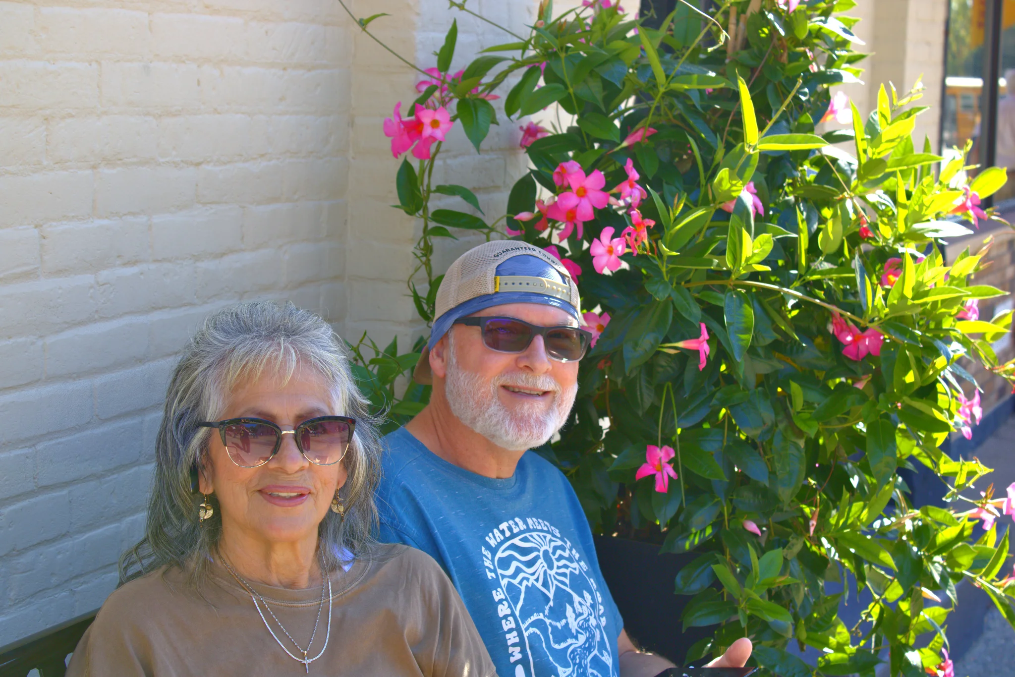 Two visitors smiling beside flowering plants at Baraboo's 2026 Fall Fair on the Square