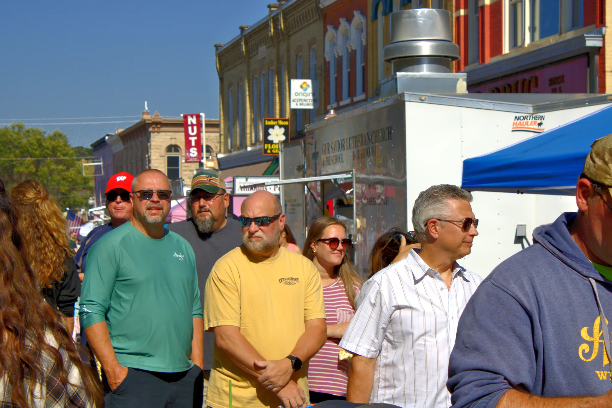 Group of visitors walking past food trucks at Baraboo's 2026 Fall Fair on the Square