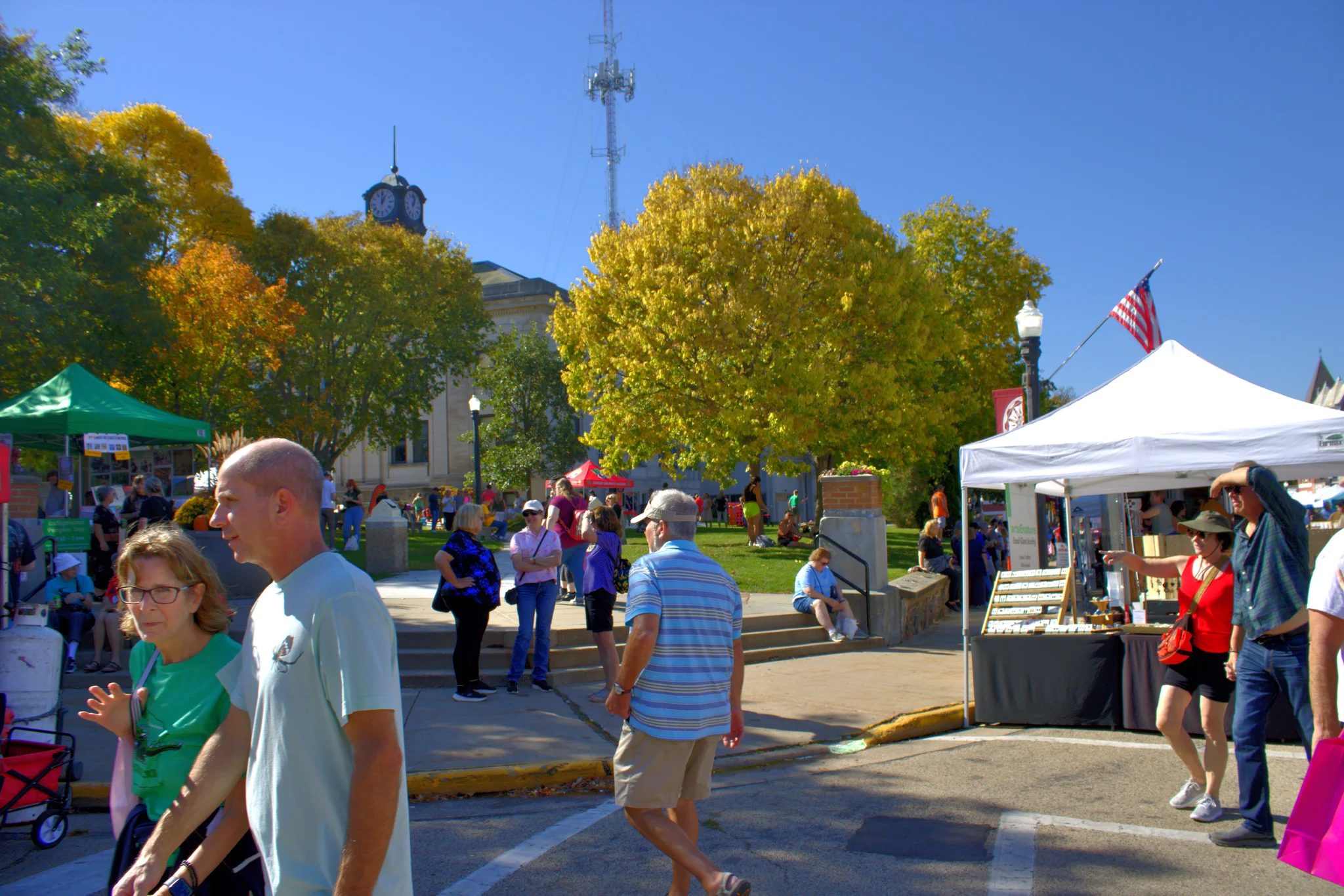 Visitors crossing the sunny courthouse square at Baraboo's 2026 Fall Fair on the Square