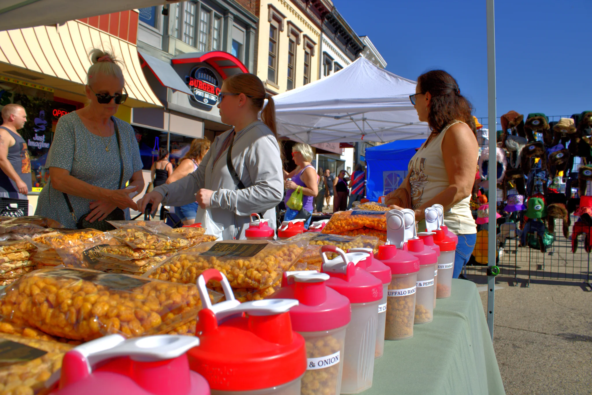 Vendor and visitors talking across a table of baked goods at Baraboo's 2026 Fall Fair on the Square