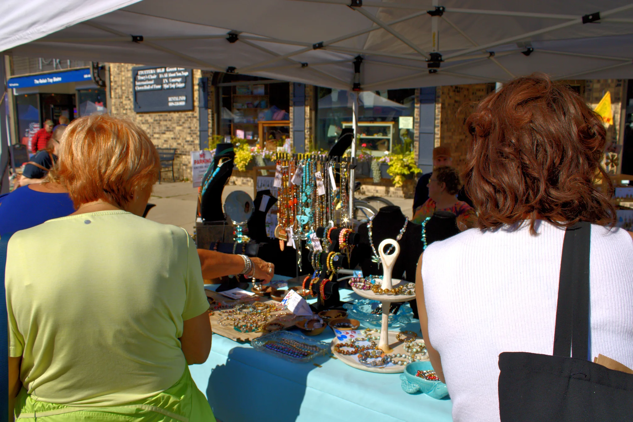 Visitors browsing crafts at a blue-covered booth at Baraboo's 2026 Fall Fair on the Square
