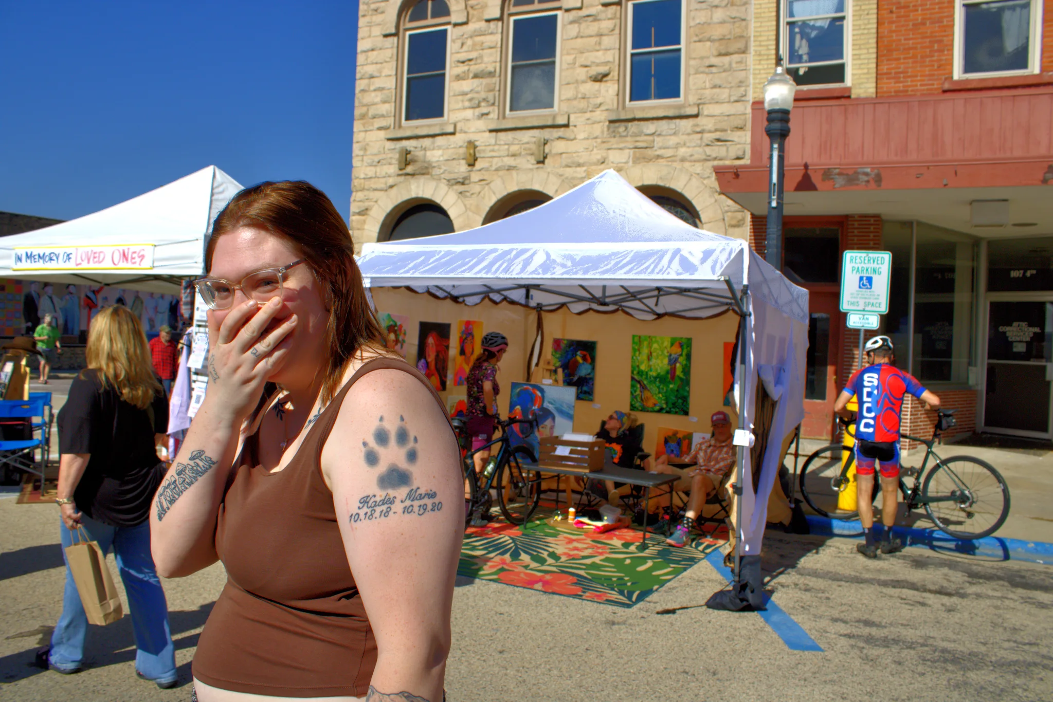 Fair visitor laughing while walking past art tents at Baraboo's 2026 Fall Fair on the Square