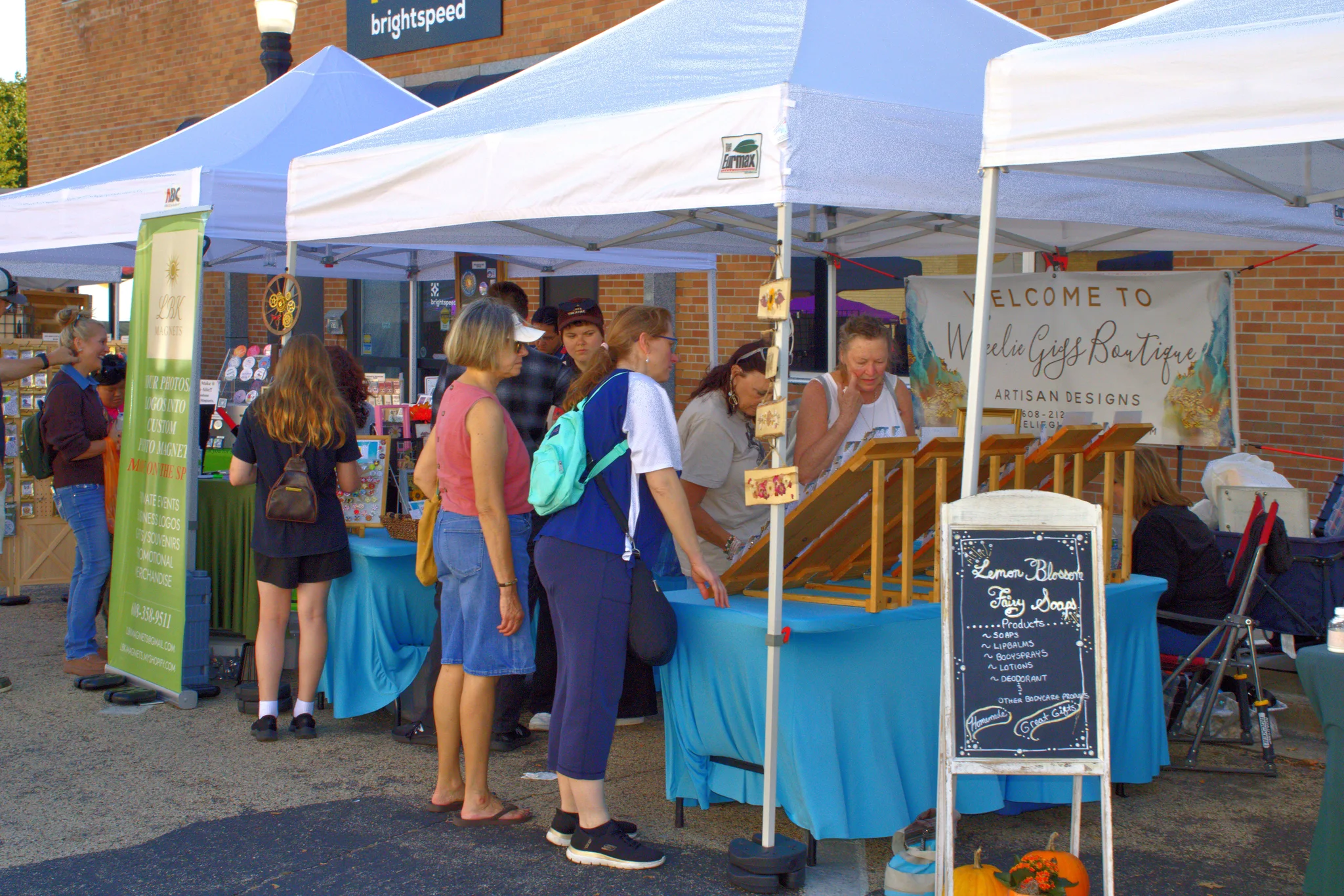 Visitors talking with vendors beneath white canopies at Baraboo's 2026 Fall Fair on the Square