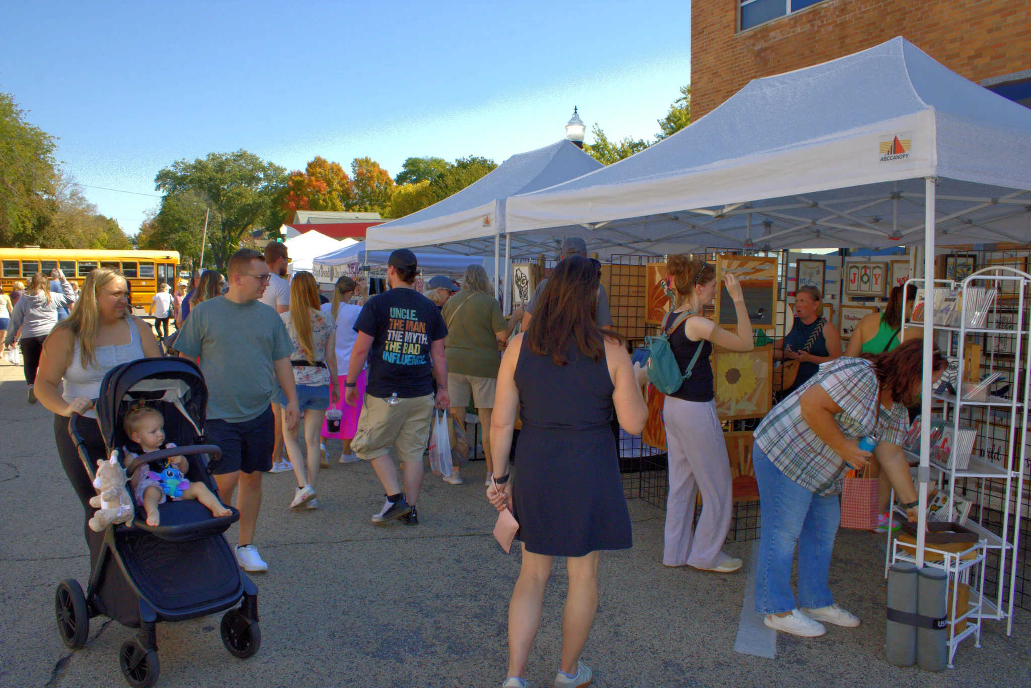 Families and shoppers passing a row of fair booths at Baraboo's 2026 Fall Fair on the Square