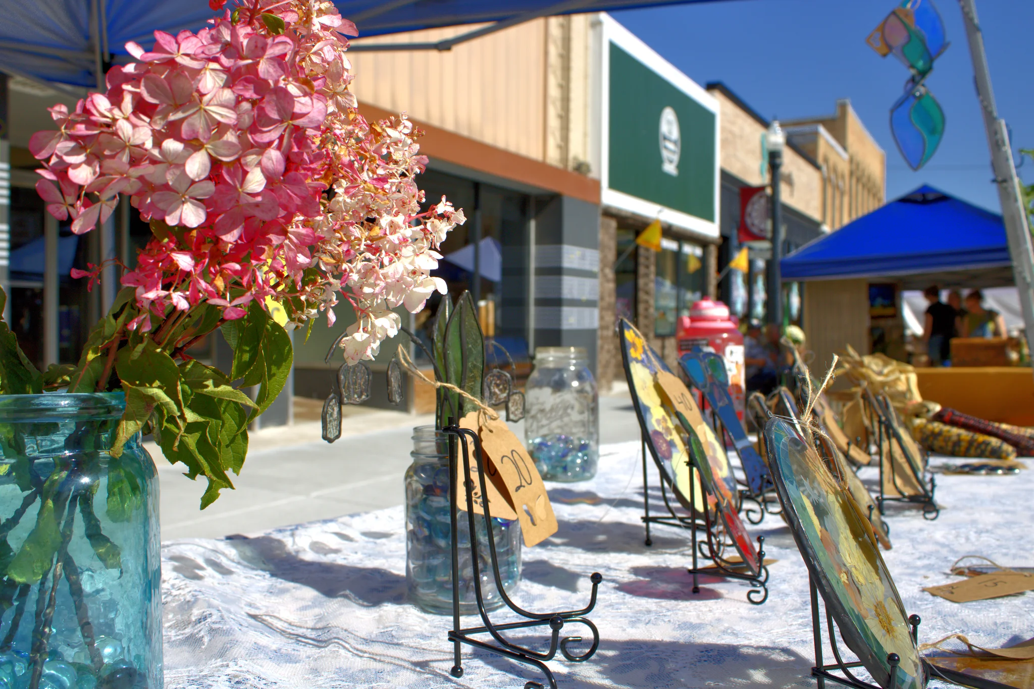 Flowers and artwork displayed beside the fair street at Baraboo's 2026 Fall Fair on the Square